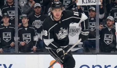 A visualization of hockey player Robert Thomas wearing a black No. 18 Los Angeles Kings jersey, skating intently on the ice while fans in casual clothing watch from behind the glass.