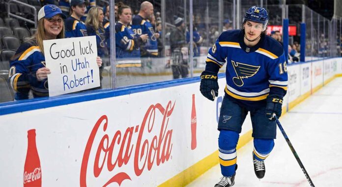 St. Louis Blues center Robert Thomas smiles as he skates past a female fan behind the glass holding a handmade sign that reads "Good luck in Utah Robert!" amidst heavy trade rumors involving the Utah Mammoth.
