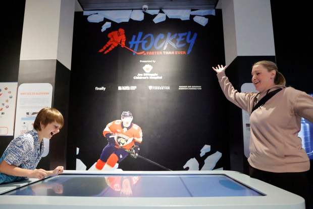 Owen Watts, left, and Kari Yazejian play electronic air hockey at the new "HOCKEY: Faster Than Ever" exhibit at the Museum of Discovery & Science in Fort Lauderdale on Friday, Jan. 30, 2026. (Amy Beth Bennett / South Florida Sun Sentinel)