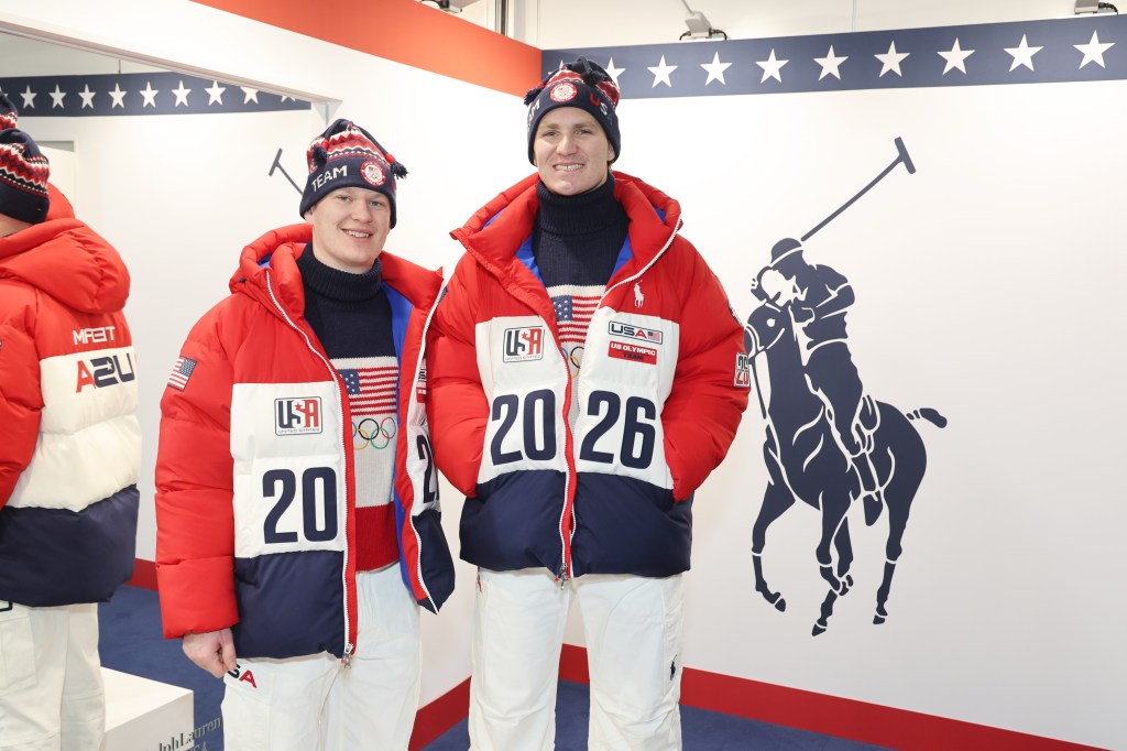 Two US Olympians, Brady Tkachuk and Matthew Tkachuk, in red, white, and blue winter coats and hats for the Milan-Cortina 2026 Olympics.