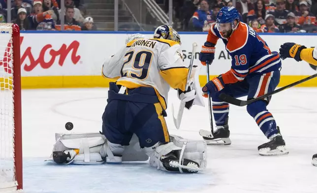 Nashville Predators goalie Justus Annunen (29) makes a save on Edmonton Oilers' Adam Henrique (19) during second period NHL action in Edmonton on Sunday, March 15, 2026. (Jason Franson/The Canadian Press via AP)