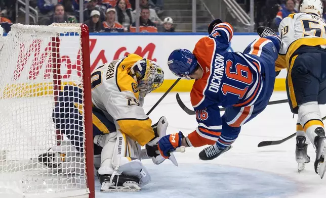 Nashville Predators goalie Justus Annunen (29) is crashed into by Edmonton Oilers' Jason Dickinson (16) during second period NHL action in Edmonton on Sunday, March 15, 2026. (Jason Franson/The Canadian Press via AP)