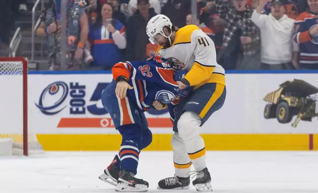 Nashville Predators' Nicolas Hague (41) and Edmonton Oilers' Vasily Podkolzin (92) fight during first period NHL action in Edmonton on Sunday, March 15, 2026. (Jason Franson/The Canadian Press via AP)