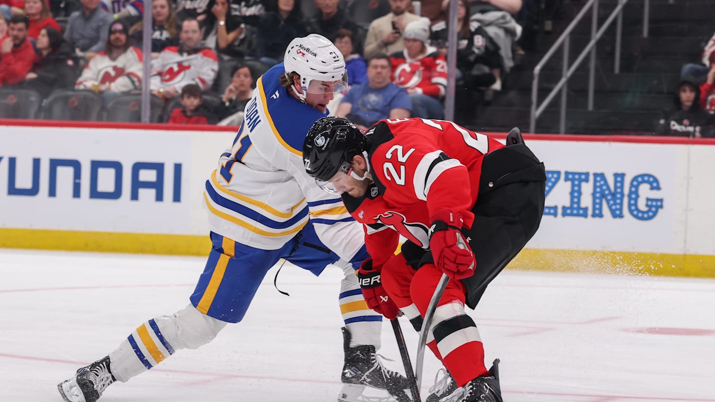 Feb 25, 2026; Newark, New Jersey, USA; Buffalo Sabres right wing Josh Doan (91) shoots the puck as New Jersey Devils defenseman Brett Pesce (22) defends during the third period at Prudential Center. Mandatory Credit: Ed Mulholland-Imagn Images