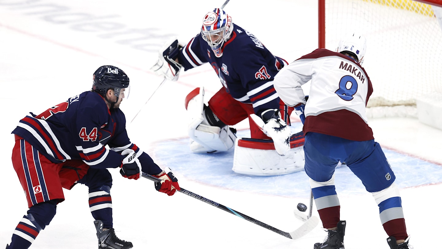 Mar 14, 2026; Winnipeg, Manitoba, CAN; Winnipeg Jets defenseman Josh Morrissey (44) stick checks Colorado Avalanche defenseman Cale Makar (8) in front of Winnipeg Jets goaltender Connor Hellebuyck (37) in the first period at Canada Life Centre. Mandatory Credit: James Carey Lauder-Imagn Images