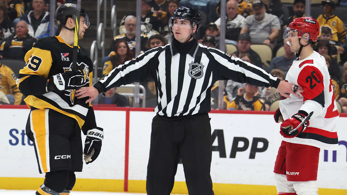 Mar 22, 2026; Pittsburgh, Pennsylvania, USA;  NHL linesman James Tobias (61) separates Pittsburgh Penguins right wing Egor Chinakhov (59) and Carolina Hurricanes center Sebastian Aho (20) during the second period at PPG Paints Arena. Mandatory Credit: Charles LeClaire-Imagn Images