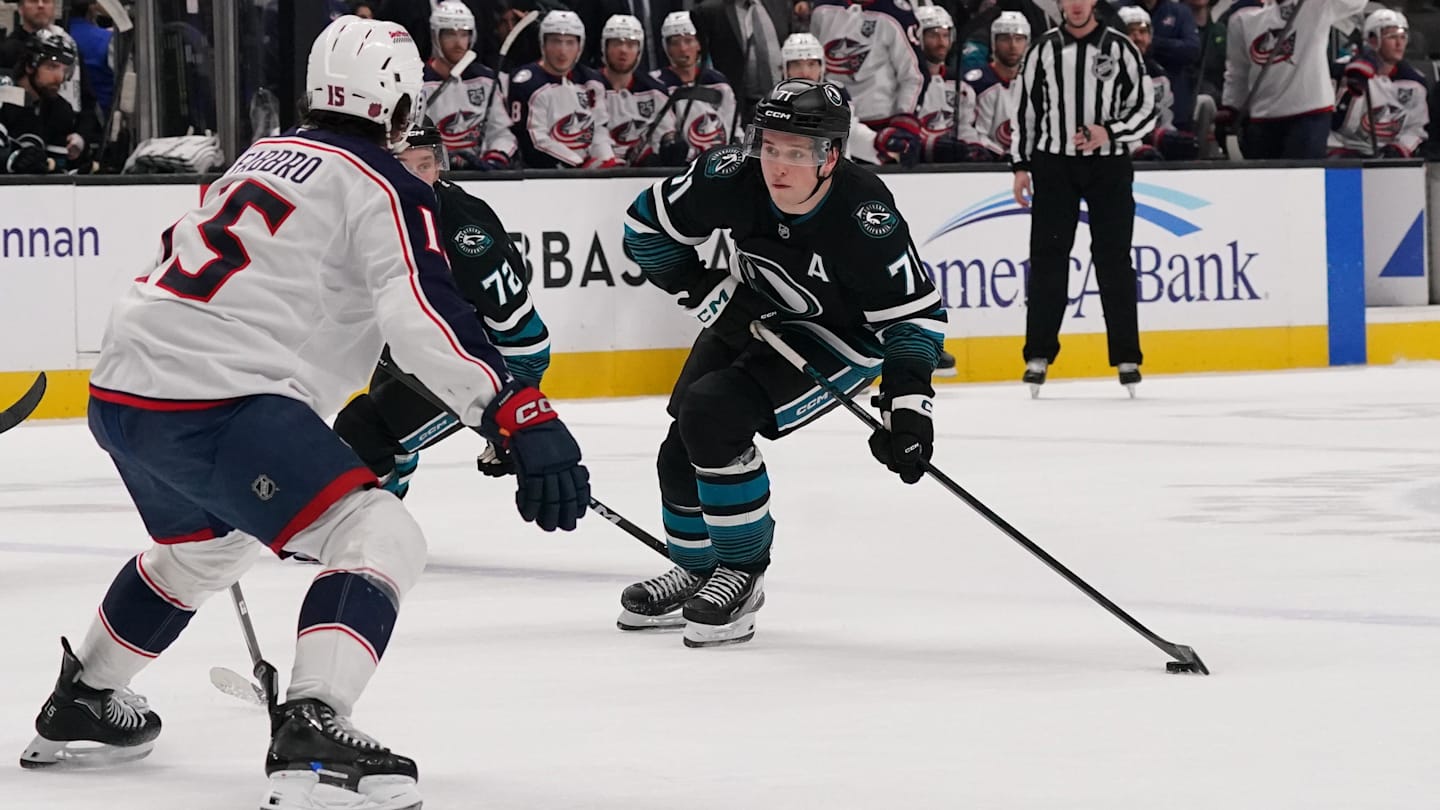 Jan 6, 2026; San Jose, California, USA; San Jose Sharks center Macklin Celebrini (71) looks to get a shot off in front of Columbus Blue Jackets defenseman Dante Fabbro (15) as San Jose Sharks left wing William Eklund (72) trails the play in the second period at SAP Center at San Jose. Mandatory Credit: David Gonzales-Imagn Images