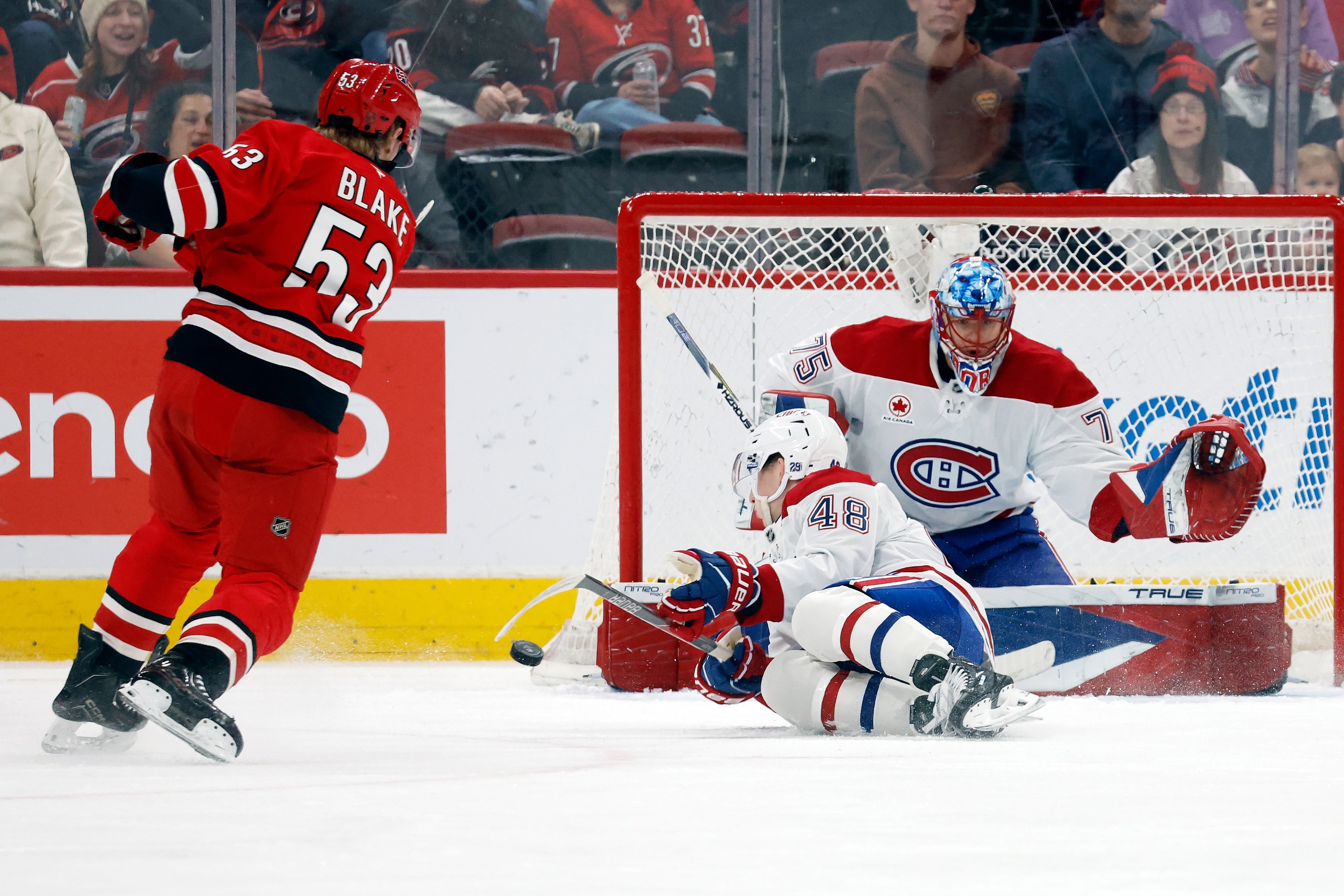 Carolina Hurricanes' Jackson Blake shoots the puck off Montreal Canadiens' Lane Hutson and wide of goaltender Jakub Dobes.