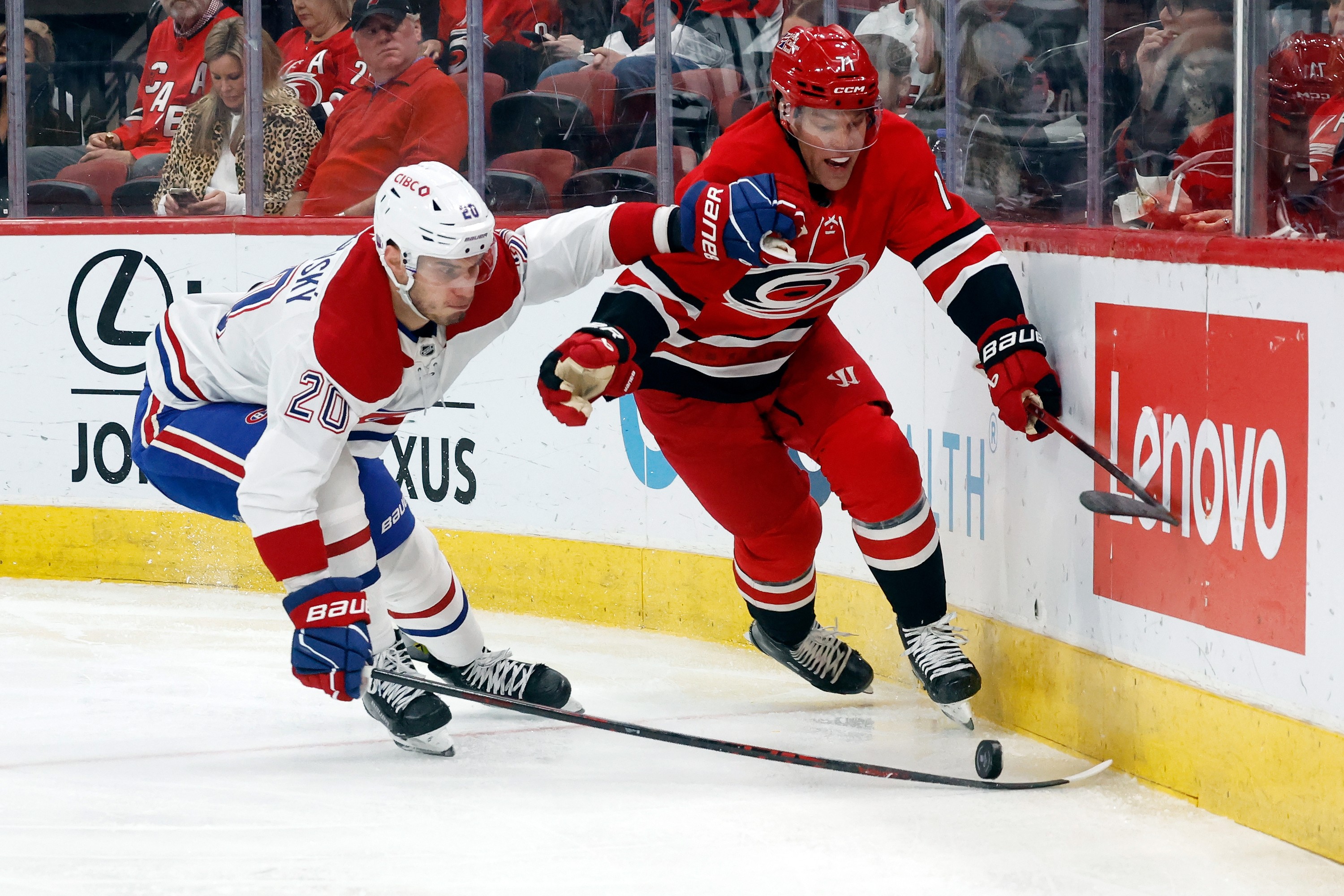 Carolina Hurricanes' Taylor Hall battles for the puck with Montreal Canadiens' Juraj Slafkovsky.