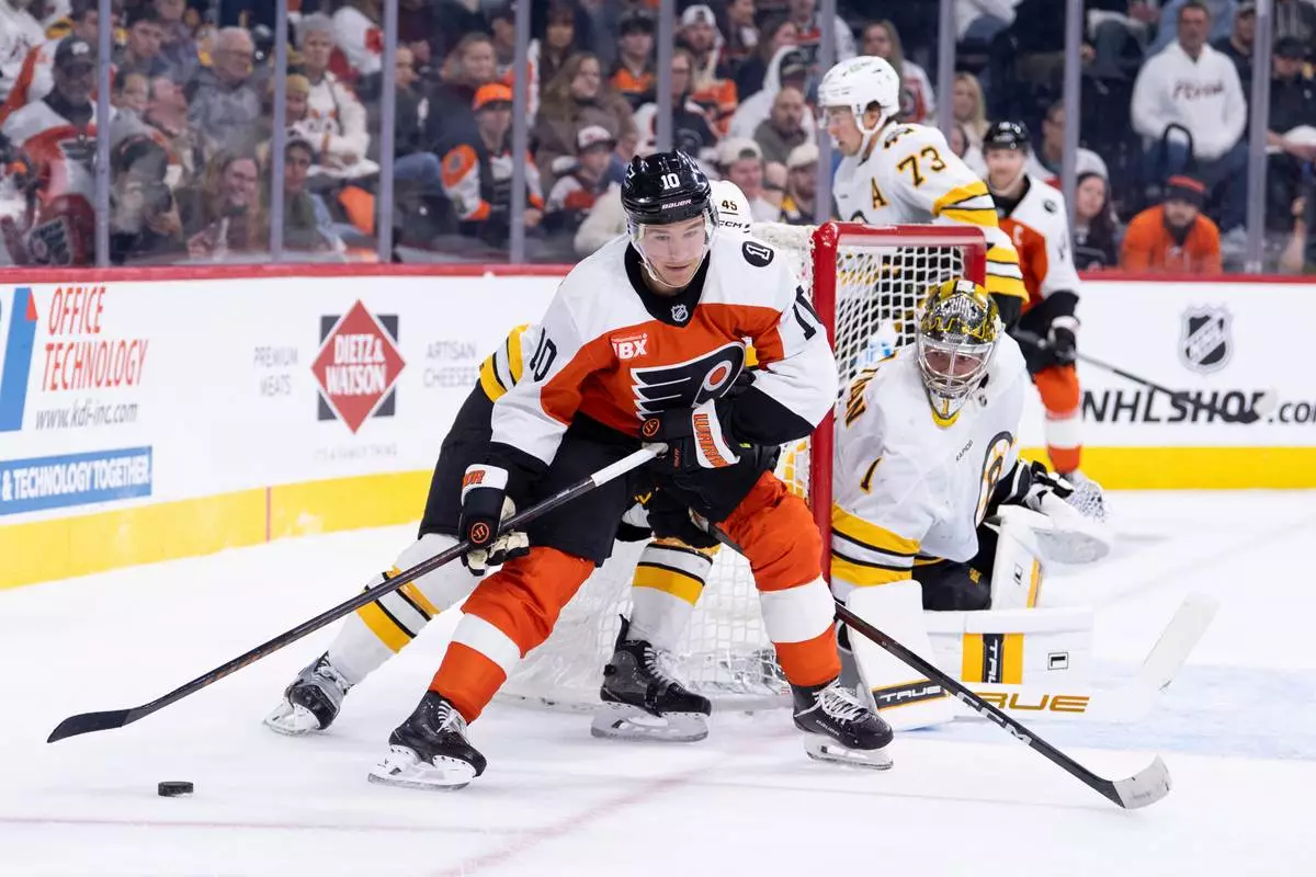 Philadelphia Flyers' Bobby Brink (10) tries to wrap the puck around Boston Bruins' goalie Jeremy Swayman (1) during the second period of an NHL hockey game Saturday, Feb. 28, 2026, in Philadelphia. (AP Photo/Chris Szagola)