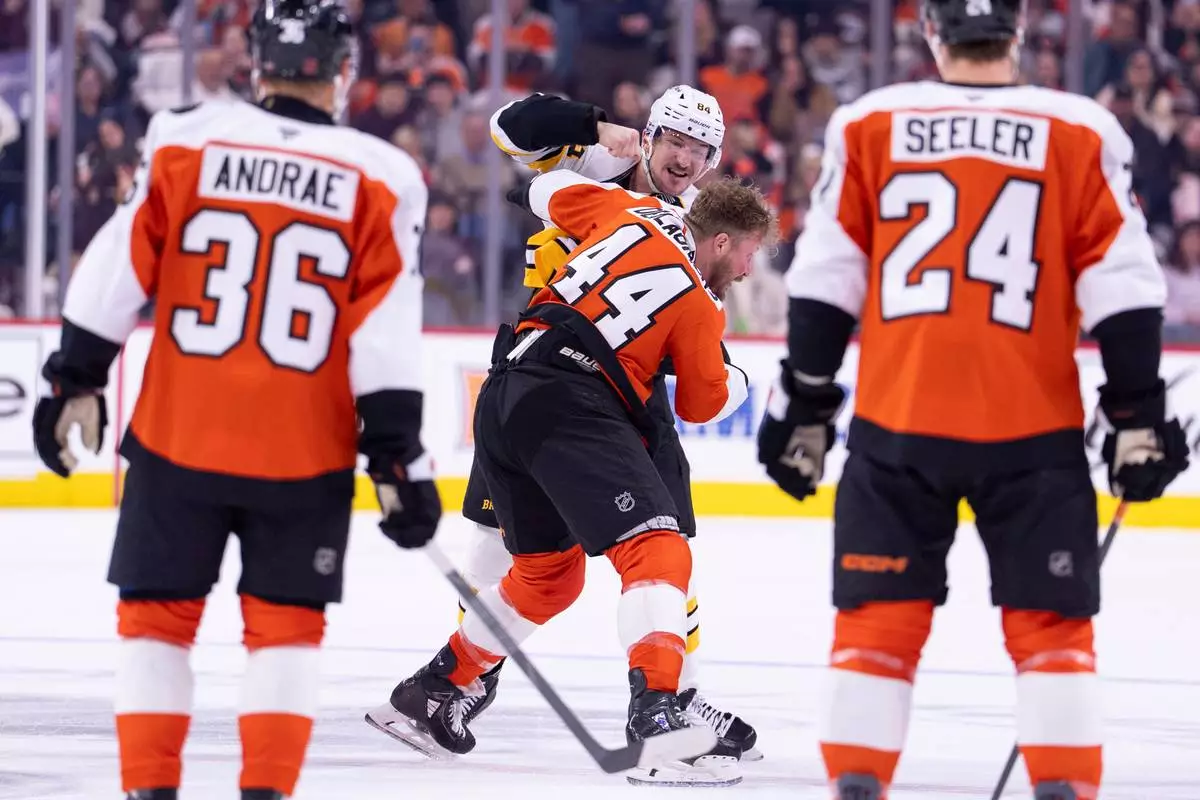 Boston Bruins' Tanner Jeannot, center left, fights with Philadelphia Flyers' Nicolas Deslauriers, center right, as teammates look on during the first period of an NHL hockey game Saturday, Feb. 28, 2026, in Philadelphia. (AP Photo/Chris Szagola)