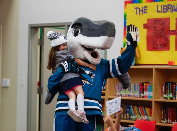 Remi, 5, hugs S.J. Sharkie during a reading initiative by the Sharks Foundation called Reading is Cool at Bachrodt Elementary in San Jose, Calif., on Thursday, March 5, 2026. (Shae Hammond/Bay Area News Group)
