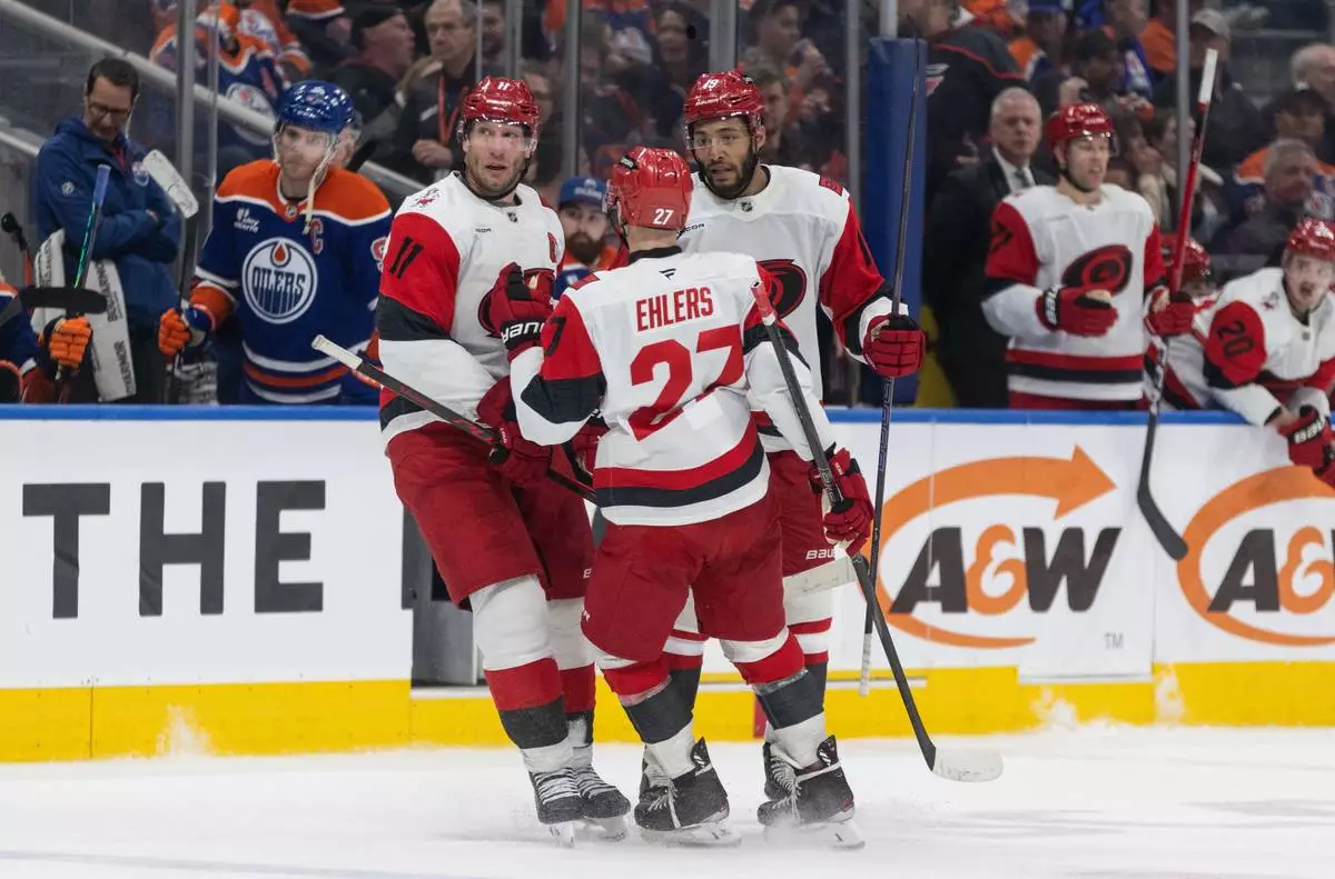 Carolina Hurricanes' Jordan Staal (11), Nikolaj Ehlers (27) and K'Andre Miller (19) celebrate a goal against the Edmonton Oilers during the third period of an NHL game, in Edmonton on Friday, March 6, 2026. (Jason Franson/The Canadian Press via AP)