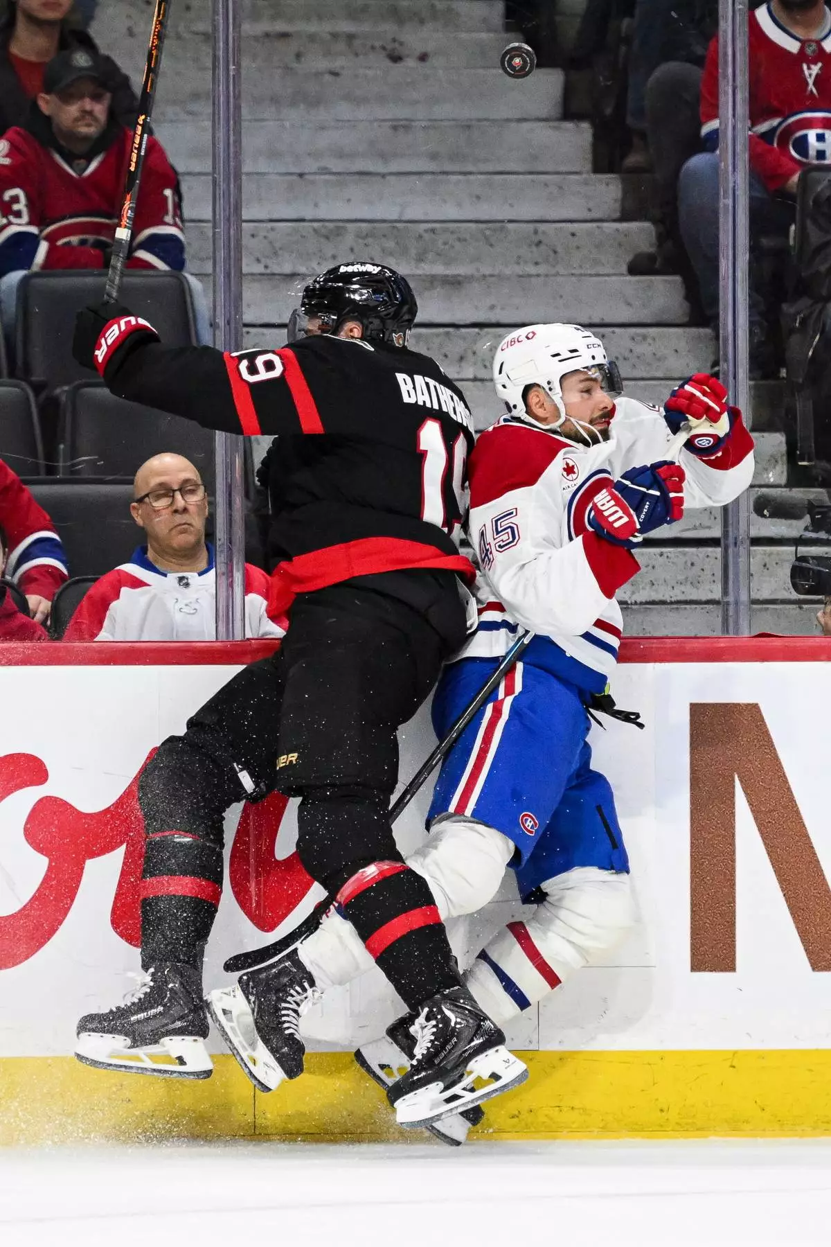 Ottawa Senators' Drake Batherson (19) checks Montreal Canadiens' Alexandre Carrier (45) along the boards during the first period of an NHL hockey game in Ottawa, Wednesday, March 11, 2026. (Spencer Colby/The Canadian Press via AP)