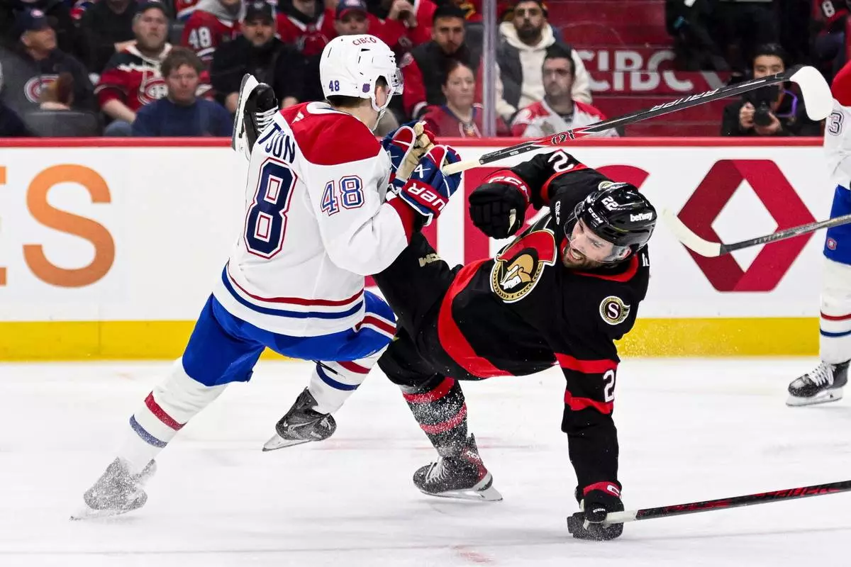 Montreal Canadiens' Lane Hutson (48) collides with Ottawa Senators' Michael Amadio (22) during the second period of an NHL hockey game in Ottawa, on Wednesday, March 11, 2026. (Spencer Colby/The Canadian Press via AP)