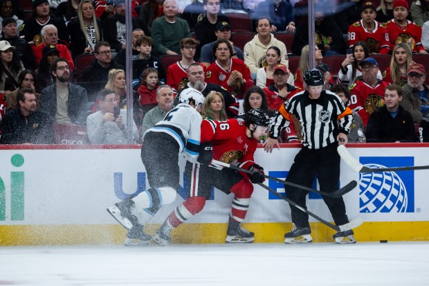 Blackhawks left wing Andrew Mangiapane (26) is hit against the boards by Mammoth defenseman John Marino on Monday, March, 9, 2026, at the United Center. (Josh Boland/Chicago Tribune)