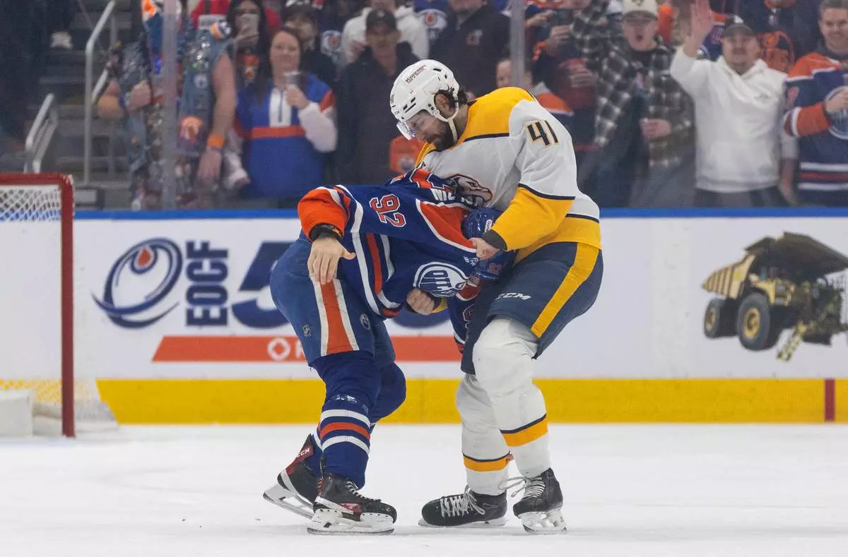 Nashville Predators' Nicolas Hague (41) and Edmonton Oilers' Vasily Podkolzin (92) fight during first period NHL action in Edmonton on Sunday, March 15, 2026. (Jason Franson/The Canadian Press via AP)