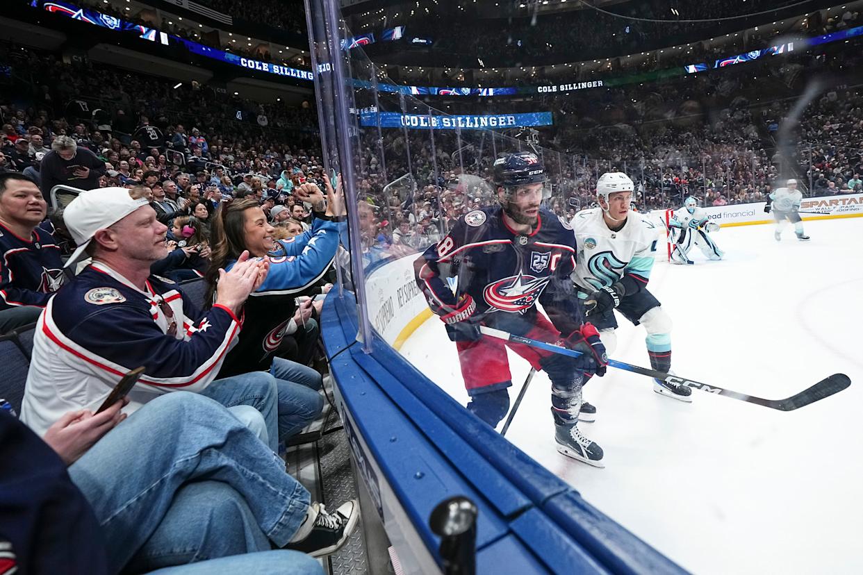 Fans cheer as Columbus Blue Jackets center Boone Jenner (38) battles for position with Seattle Kraken defenseman Ryker Evans (41) during the third period of the NHL hockey game at Nationwide Arena on March 21, 2026. The Blue Jackets won 5-2.