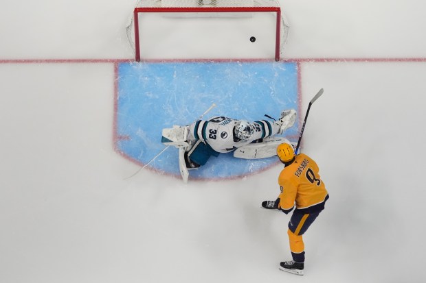 Nashville Predators left wing Filip Forsberg (9) scores a goal past San Jose Sharks goaltender Alex Nedeljkovic (33) during the first period of an NHL hockey game Tuesday, March 24, 2026, in Nashville, Tenn. (AP Photo/George Walker IV)