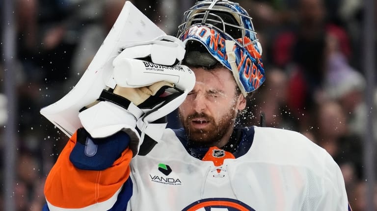 New York Islanders goaltender Ilya Sorokin splashes water on his...