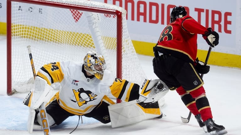 Pittsburgh Penguins goaltender Stuart Skinner (74) makes a glove save...