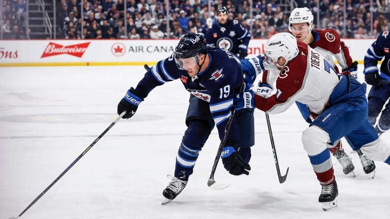 Colorado Avalanche's Devon Toews (7) defends against Winnipeg Jets' Jonathan...