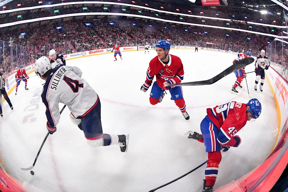 Columbus Blue Jackets forward Cole Sillinger (4) plays the puck in the corner while Montreal Canadiens forward Jake Evans (71) defends during the first period at the Bell Centre.