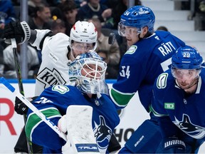 Vancouver Canucks goaltender Kevin Lankinen (32), Aatu Raty (54), Marcus Pettersson (29) and Los Angeles Kings' Adrian Kempe (9) watch the puck during the second period of an NHL hockey game in Vancouver, on Thursday, March 26, 2026.