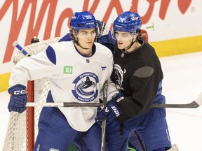Liam Ohgren and Zeev Buium jostle in front of the net at Canucks practice at Rogers Arena on Wednesday