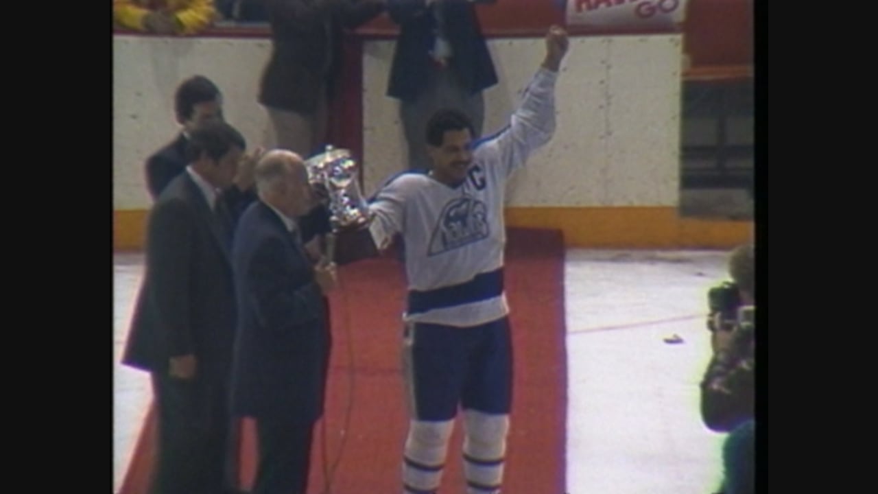 a man in hockey gear holds a trophy