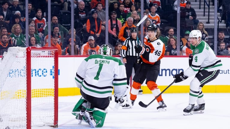 Philadelphia Flyers center Trevor Zegras, center, shoots the puck past...