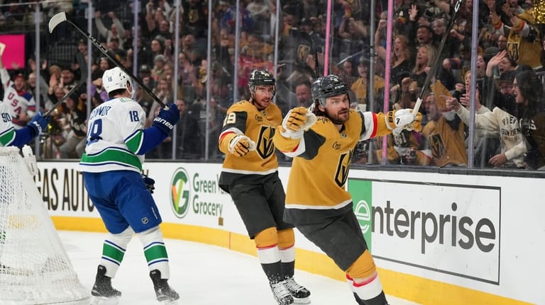 Vegas Golden Knights defenseman Rasmus Andersson, right, celebrates after his...