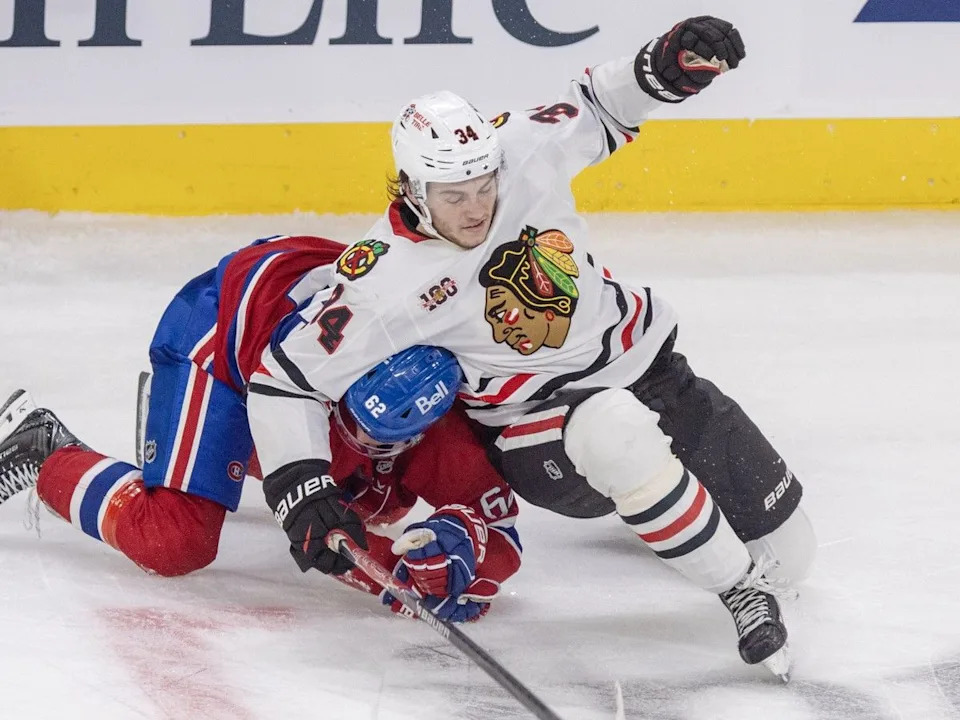  Montreal Canadiens forward Owen Beck is hauled to the ice by Chicago Blackhawks forward Colton Dach during the third period in Montreal on Thursday Dec.18, 2025.