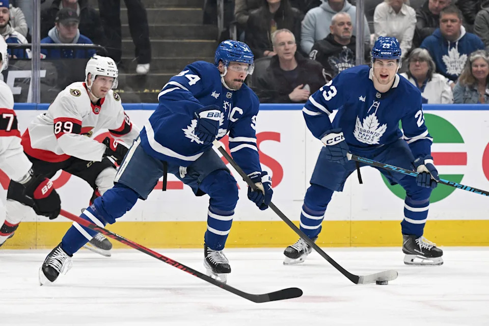 Feb 28, 2026; Toronto, Ontario, CAN; Toronto Maple Leafs forward Auston Matthews (34) passes the puck away from Ottawa Senators forward Lars Eller (89) as forward Matthew Knies (23) looks on in the first period at Scotiabank Arena. Mandatory Credit: Dan Hamilton-Imagn Images