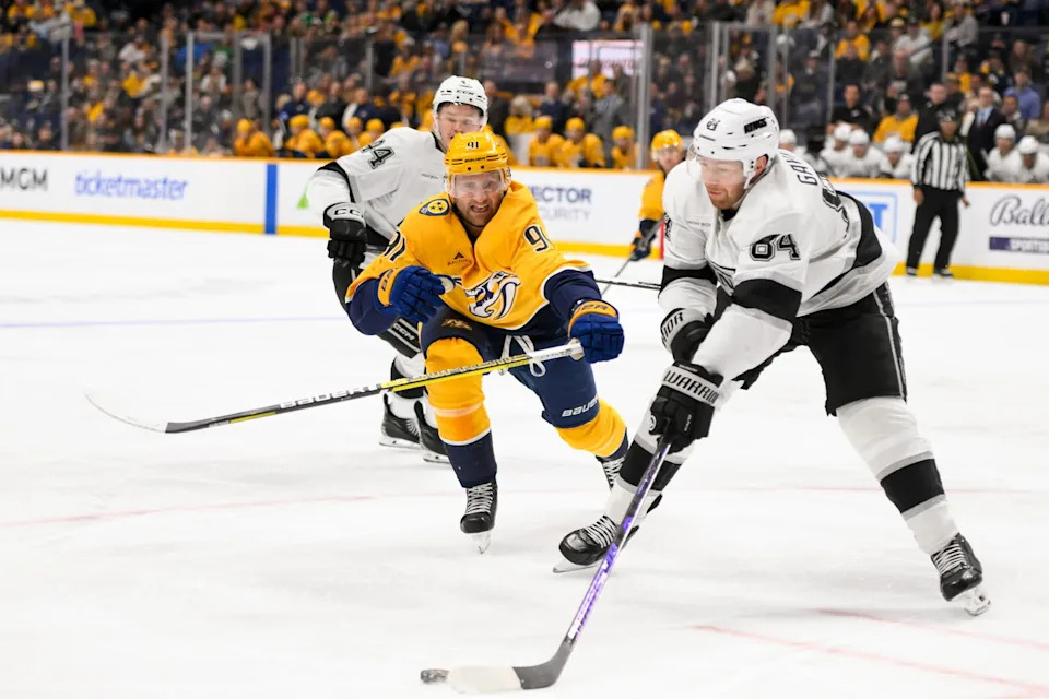 Dec 21, 2024; Nashville, Tennessee, USA; Nashville Predators center Steven Stamkos (91) and Los Angeles Kings defenseman Vladislav Gavrikov (84) battle for the puck during the third period at Bridgestone Arena. Mandatory Credit: Steve Roberts-Imagn Images