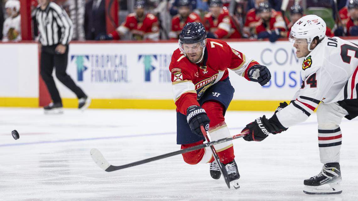 Florida Panthers defenseman Dmitry Kulikov (7) and Chicago Blackhawks center Colton Dach (34) compete for the puck in the second period of their NHL game at Amerant Bank Arena on Tuesday, Oct. 7, 2025, in Sunrise, Fla.