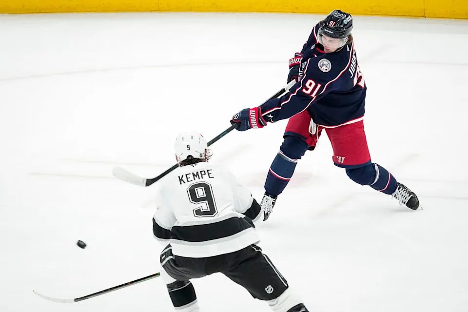 Columbus Blue Jackets center Kent Johnson (91) shoots past Los Angeles Kings right wing Adrian Kempe (9) during the second period of the NHL hockey game at Nationwide Arena in Columbus on March 9, 2026.