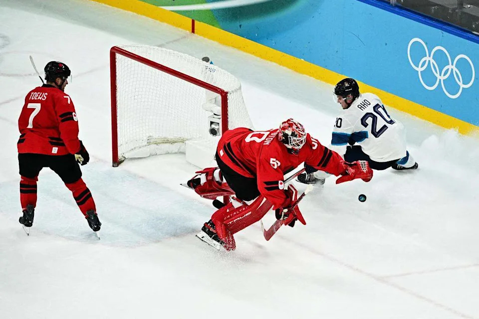 Canadian goalie Jordan Binnington dives for the puck as he defends against Finland's Sebastian Aho during the men's semifinal between Canada and Finland at the Milano Santagiulia Ice Hockey Arena during the Milano Cortina 2026 Winter Olympic Games in Milan, on Feb. 20, 2026.
