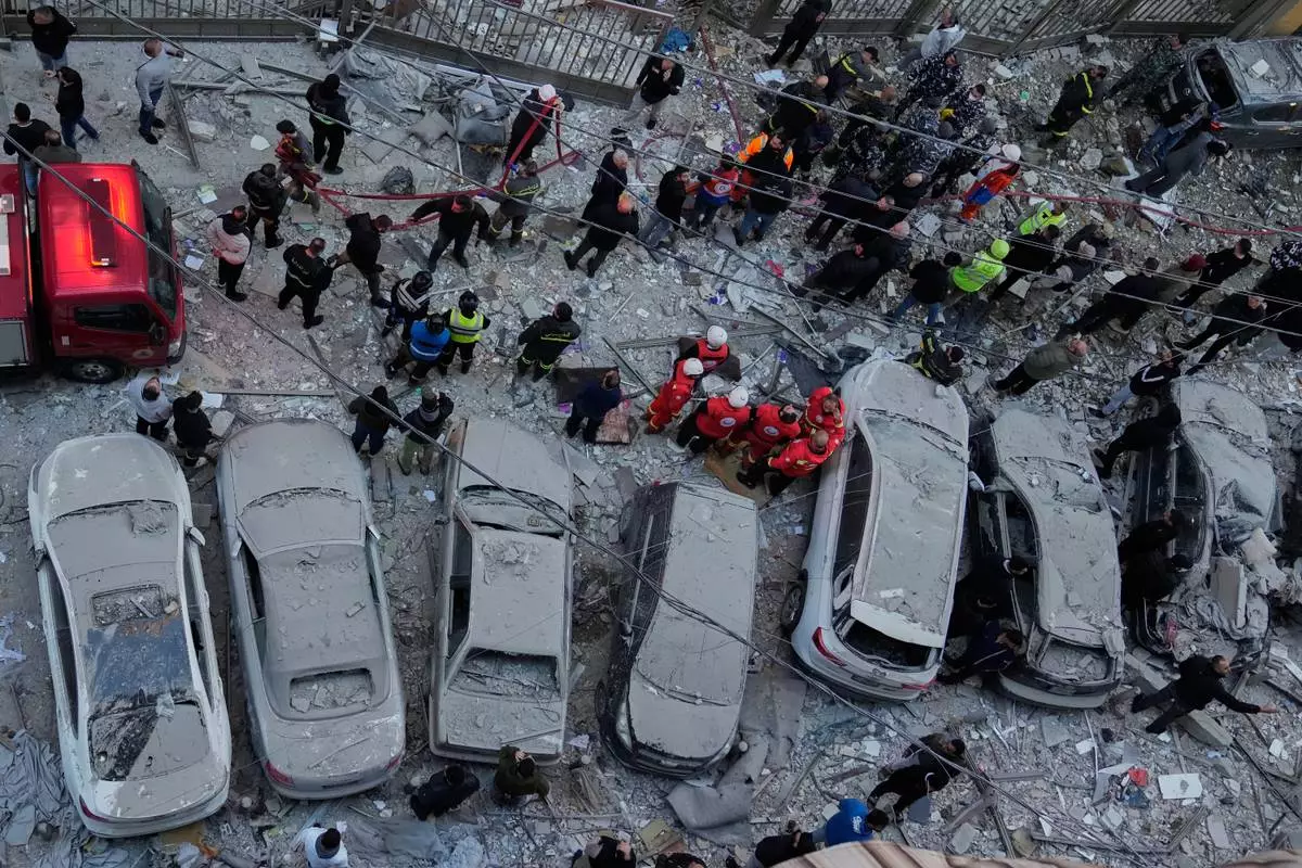 Rescue workers gather at the site where Israeli airstrikes hit apartments in Beirut, Lebanon, Wednesday, March 11, 2026. (AP Photo/Hussein Malla)