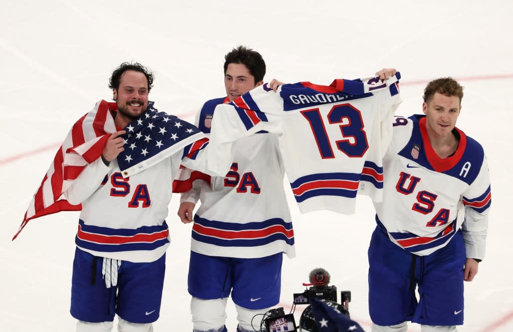 Auston Matthews (l.), Zach Werenski (c.) and Matthew Tkachuk (r.) carry Johnny Gaudreau’s jersey after Team USA’s gold-medal win over Canada on Feb. 22, 2026. Getty Images