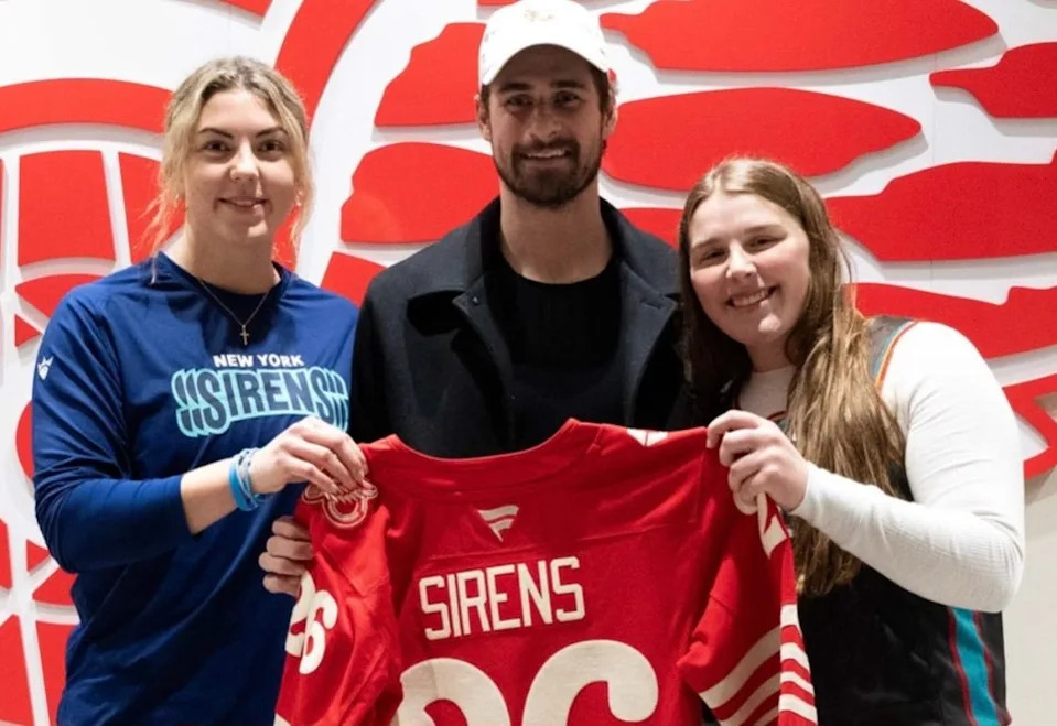 Red Wings captain Dylan Larkin meets with Commerce Township's Callie Shanahan, left, and Livonia's Kaley Doyle before Saturday's PWHL game between the New York Sirens and Montreal Victoire. Shanahan and Doyle are goaltenders with the Sirens.
