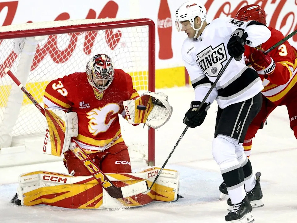  Flames goalie Dustin Wolf stops Kings forward Jared Wright.