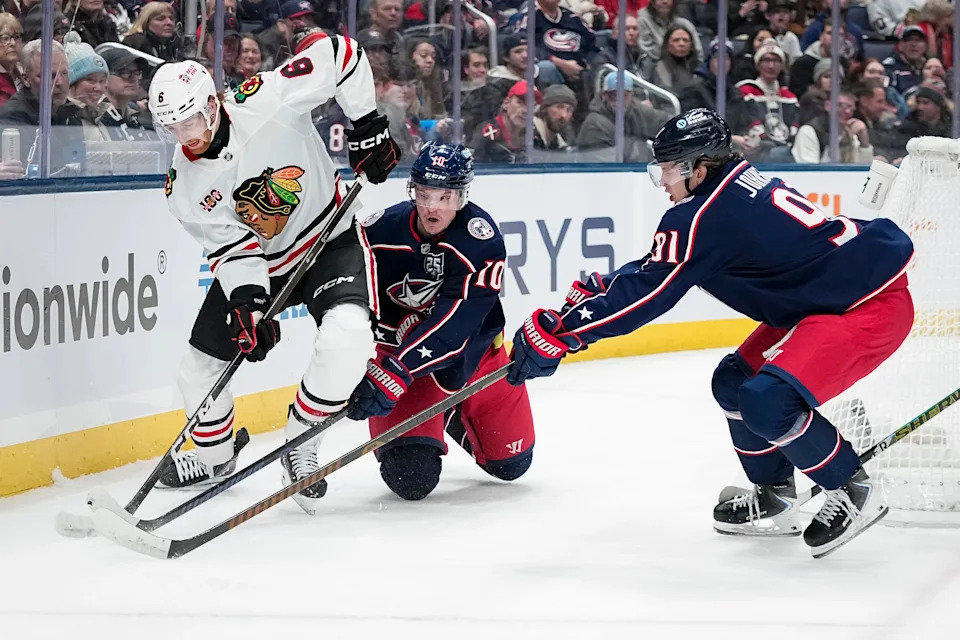 Columbus Blue Jackets left wing Dmitri Voronkov (10) and center Kent Johnson (91) defend Chicago Blackhawks defenseman Sam Rinzel (6) during the first period of the NHL hockey game at Nationwide Arena on Feb. 4, 2026.