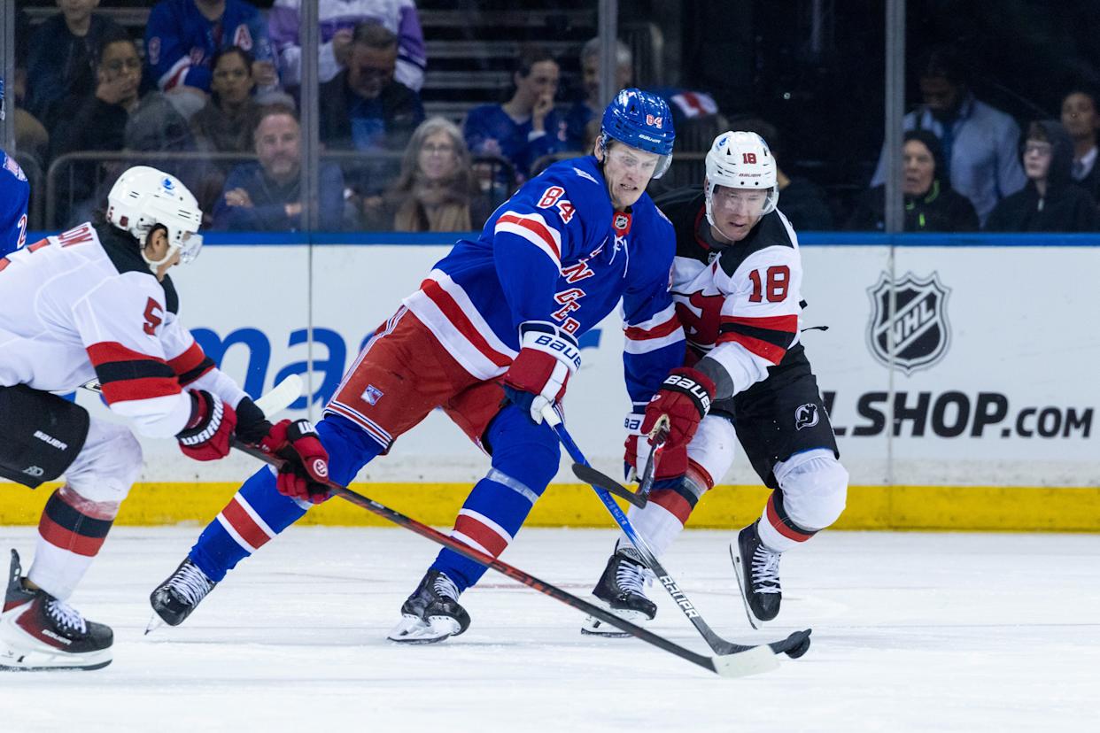 New York Rangers center Adam Edstrom (84) and New Jersey Devils left wing Ondrej Palat (18) fight for possession of the puck.