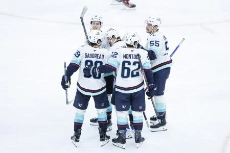 Nov 20, 2025; Chicago, Illinois, USA; Seattle Kraken left wing Tye Kartye (12) celebrates with teammates after scoring against the Chicago Blackhawks during the third period at United Center.