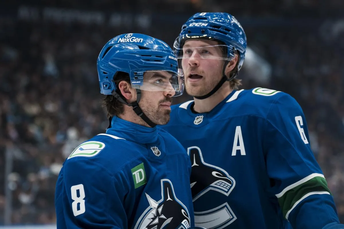 Vancouver Canucks forward Brock Boeser (6) talks with forward Conor Garland (8) during a stop in play against the San Jose Sharks in the second period at Rogers Arena.