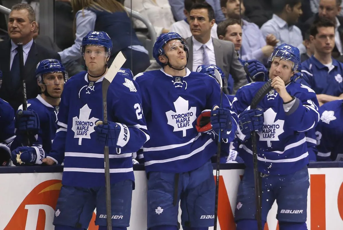 Toronto Maple Leafs center Peter Holland (24) and right wing Richard Panik (18) and center Leo Komarov (47) and head coach Peter Horachek look on during a break in the action against the New York Islanders at Air Canada Centre. The Islanders beat the Maple Leafs 4-3 in overtime.