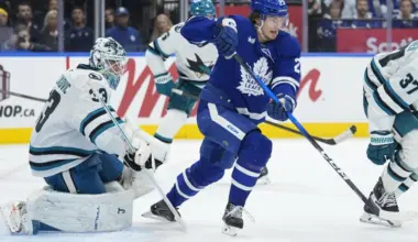 Toronto Maple Leafs forward Matthew Knies (23) and San Jose Sharks goaltender Alex Nedeljkovic (33) look for the puck during the third period at Scotiabank Arena.