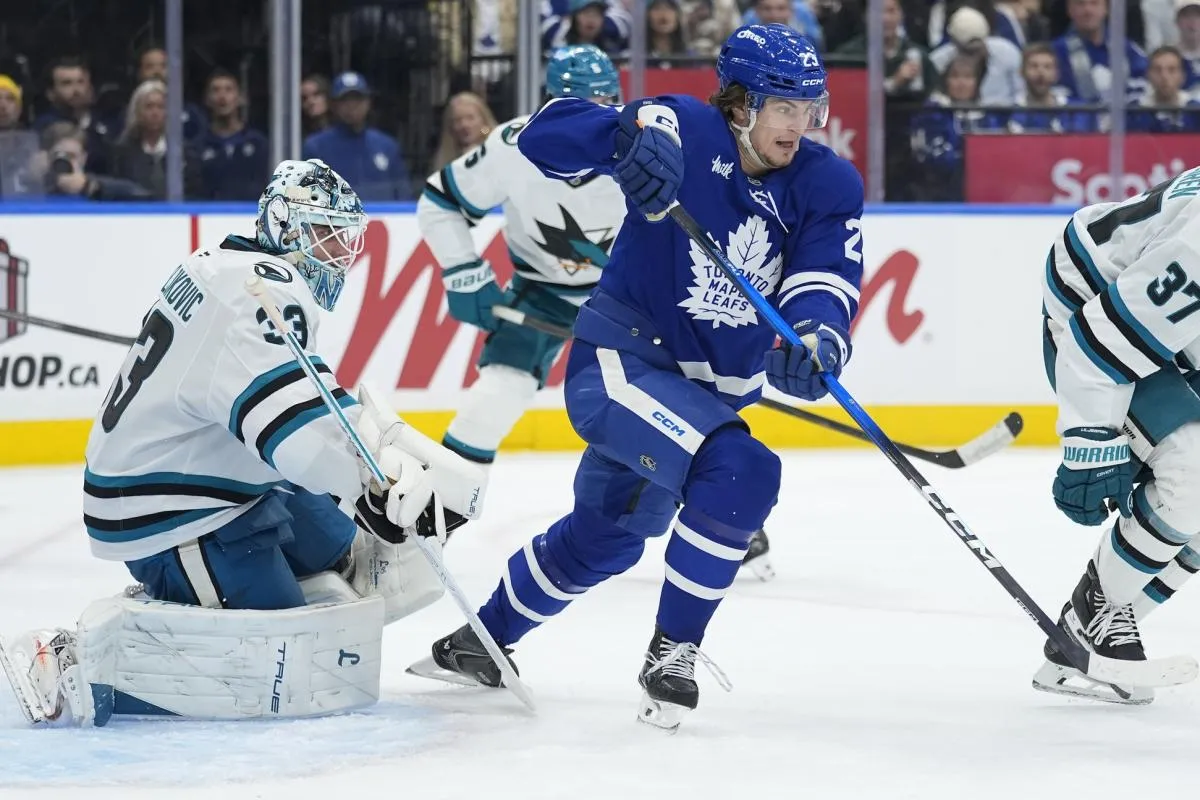 Toronto Maple Leafs forward Matthew Knies (23) and San Jose Sharks goaltender Alex Nedeljkovic (33) look for the puck during the third period at Scotiabank Arena.