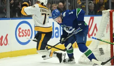 Vancouver Canucks defenseman Tom Willander (5) checks Nashville Predators right wing Luke Evangelista (77) during the first period at Rogers Arena.